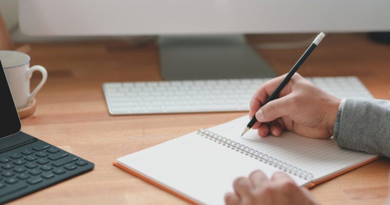 ノートにペンで書いている