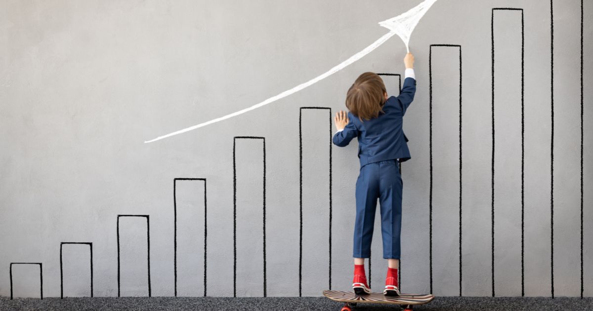 子どもがスケボーに乗って上に向かって白い矢印を書いている